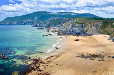 an aerial view of a beach with rocks and the ocean at The Cliffs - Sunset Village Beach 1A in Viveiro