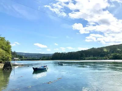 two boats in the water on a river at The Cliffs - Sunset Village Beach 1A in Viveiro