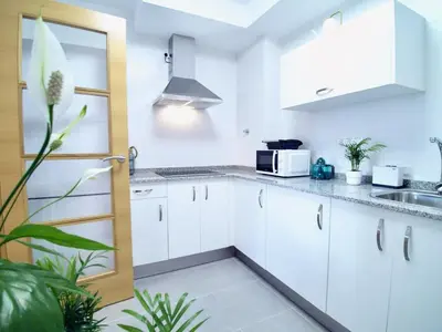 a kitchen with white cabinets and a sink at The Cliffs - Sunset Village Beach 1A in Viveiro