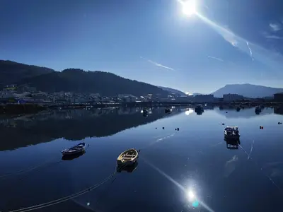 three boats are docked in a large body of water at The Cliffs - Sunset Village Beach 1C in Viveiro