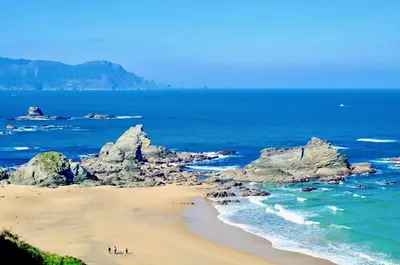 a group of people on a beach near the ocean at The Cliffs - Sunset Village Beach 1C in Viveiro