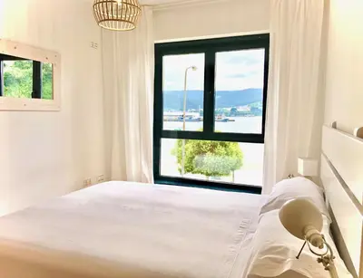 a bedroom with a bed and a large window at The Cliffs - Sunset Village Beach 1D in Viveiro