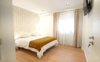 a bedroom with a bed and a window at NOBE ROOMS in Santiago de Compostela