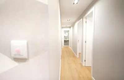 a hallway with white walls and a wooden floor at NOBE ROOMS in Santiago de Compostela
