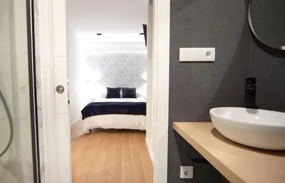 a bathroom with a sink and a bed at NOBE ROOMS in Santiago de Compostela