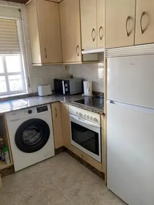 a kitchen with a washing machine and a refrigerator at entrepraciñas 1 in Santiago de Compostela