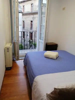 a bedroom with a bed and a large window at entrepraciñas 2 in Santiago de Compostela