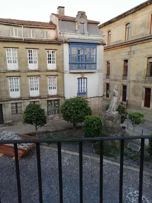 a building with a statue in front of it at entrepraciñas 2 in Santiago de Compostela