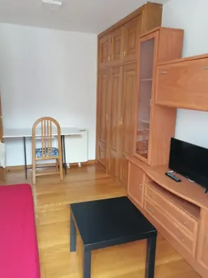 a living room with a desk and a table at entrepraciñas 2 in Santiago de Compostela