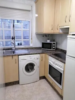 a kitchen with a washing machine and a microwave at entrepraciñas 2 in Santiago de Compostela