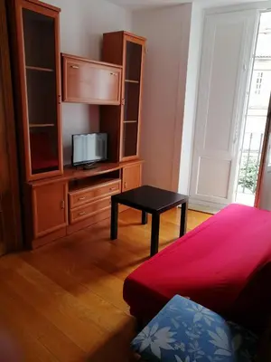 a bedroom with a bed and a cabinet with a television at entrepraciñas 2 in Santiago de Compostela