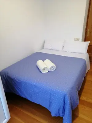 two towels are sitting on a blue bed at entrepraciñas 2 in Santiago de Compostela