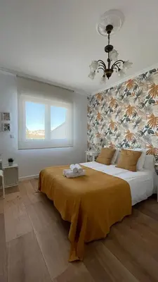 a bedroom with a bed and a window and a chair at Falda do Pedroso in Santiago de Compostela