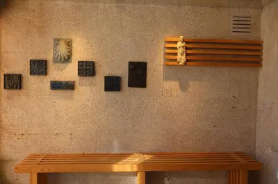 a wooden bench in front of a wall with pictures at Loop INN Hostel Santiago de Compostela in Santiago de Compostela
