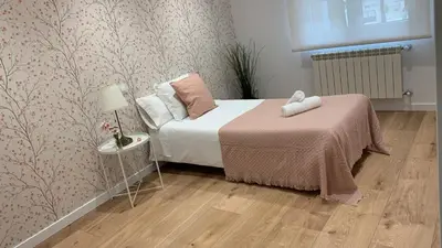 a bedroom with a bed and a table with a lamp at Campo de Estrellas in Santiago de Compostela