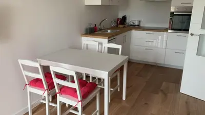 a kitchen with a white table and chairs with red pillows at Campo de Estrellas in Santiago de Compostela