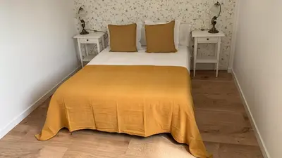 a bedroom with a bed with a yellow blanket on it at Campo de Estrellas in Santiago de Compostela