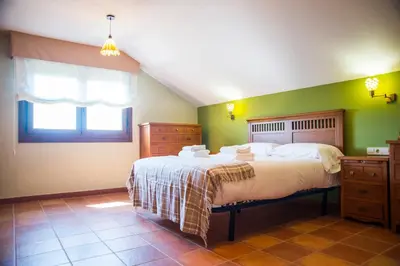 a bedroom with a large bed with green walls at Welcome Villa Briallos in Portas