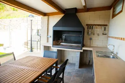 a kitchen with a stove and a table with a tableablish at Welcome Villa Briallos in Portas