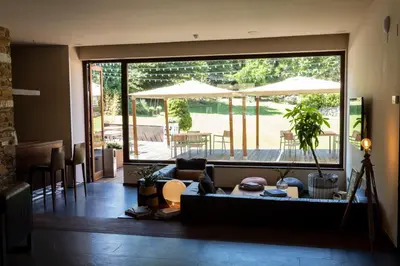 a living room with a couch and tables and umbrellas at No-Mad Green Hotel in Molinaseca