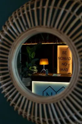 a mirror with a lamp and a sign that says be normal not mad at No-Mad Green Hotel in Molinaseca