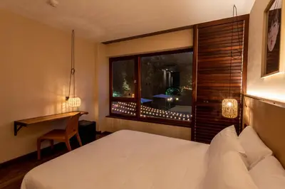 a bedroom with a bed and a desk and a window at No-Mad Green Hotel in Molinaseca
