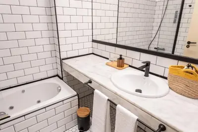 a white bathroom with a sink and a tub at No-Mad Green Hotel in Molinaseca