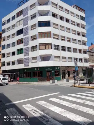a large white building on the corner of a street at APARTAMENTO RAFER in Ribadeo