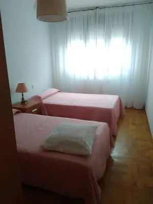 a room with three beds and a window at APARTAMENTO RAFER in Ribadeo