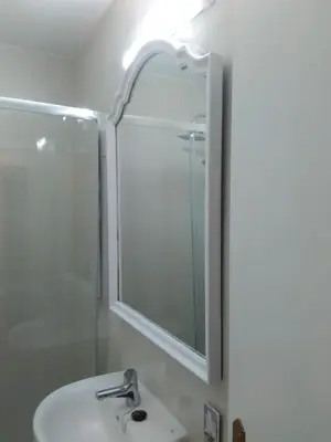 a bathroom with a sink and a shower and a mirror at APARTAMENTO RAFER in Ribadeo