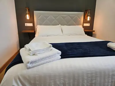 a bedroom with a bed with towels on it at Apartamentos Rurales Lola Penarronda in Castropol
