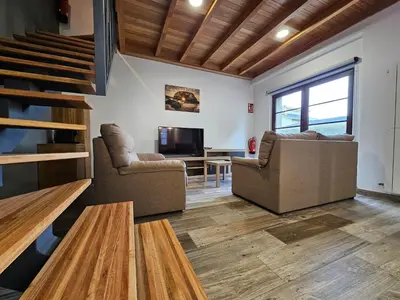 a living room with two chairs and a television at Apartamentos Rurales Lola Penarronda in Castropol