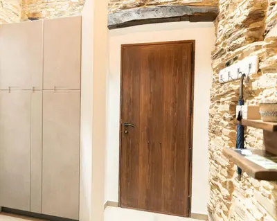 a wooden door in a room with a stone wall at Finca Eiras in Lugo