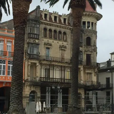 an old building with two palm trees in front of it at Finca Eiras in Lugo