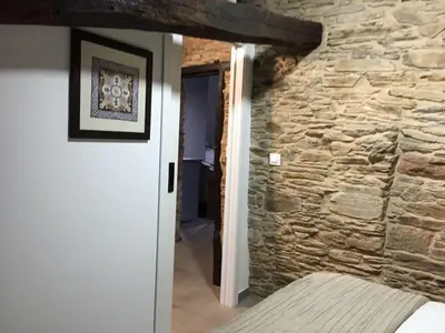 a room with a stone wall next to a door at Finca Eiras in Lugo