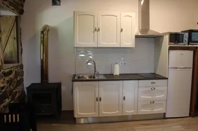 a kitchen with white cabinets and a sink and a stove at A Nosa Casa 2 in Belesar