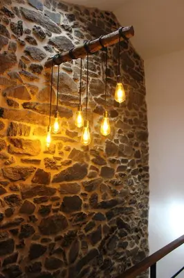 a stone wall with lights hanging from it at A Nosa Casa 2 in Belesar