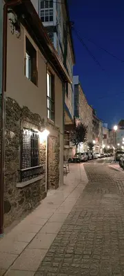 a building on the side of a street at night at La Casita de Sofía in Monforte de Lemos