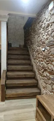 a staircase in a stone wall with wooden steps at La Casita de Sofía in Monforte de Lemos