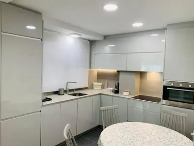 a kitchen with white cabinets and a table in it at Viveiro Centro in Viveiro