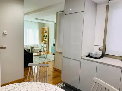 a kitchen with white cabinets and a table and chairs at Viveiro Centro in Viveiro