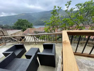 a balcony with benches and a view of a mountain at Ecolagar O Barqueiro in Pantón
