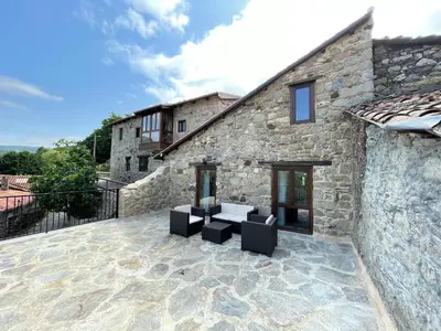 a patio with two chairs and a building at Ecolagar O Barqueiro in Pantón