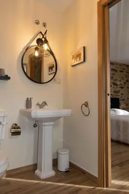 a bathroom with a sink and a mirror on the wall at Ecolagar O Barqueiro in Pantón