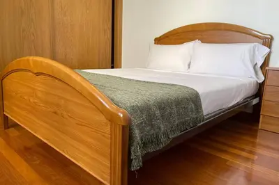 a bedroom with a bed with a wooden headboard at Oktheway Calvo Sotelo in Sarria
