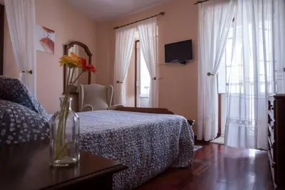 a bedroom with a bed and a vase of flowers on a table at Casa Morazón Fontán Sada in Sada