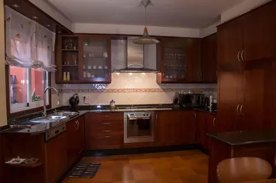 a kitchen with wooden cabinets and a sink at Casa Morazón Fontán Sada in Sada