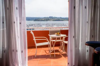 a balcony with a table and chairs and a window at Casa Morazón Fontán Sada in Sada