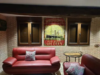 a red couch sitting in front of a brick wall at Casa Honorio in Santa Marina del Sil