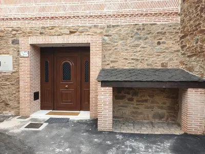 a brick building with a wooden door and a brick oven at Casa Honorio in Santa Marina del Sil